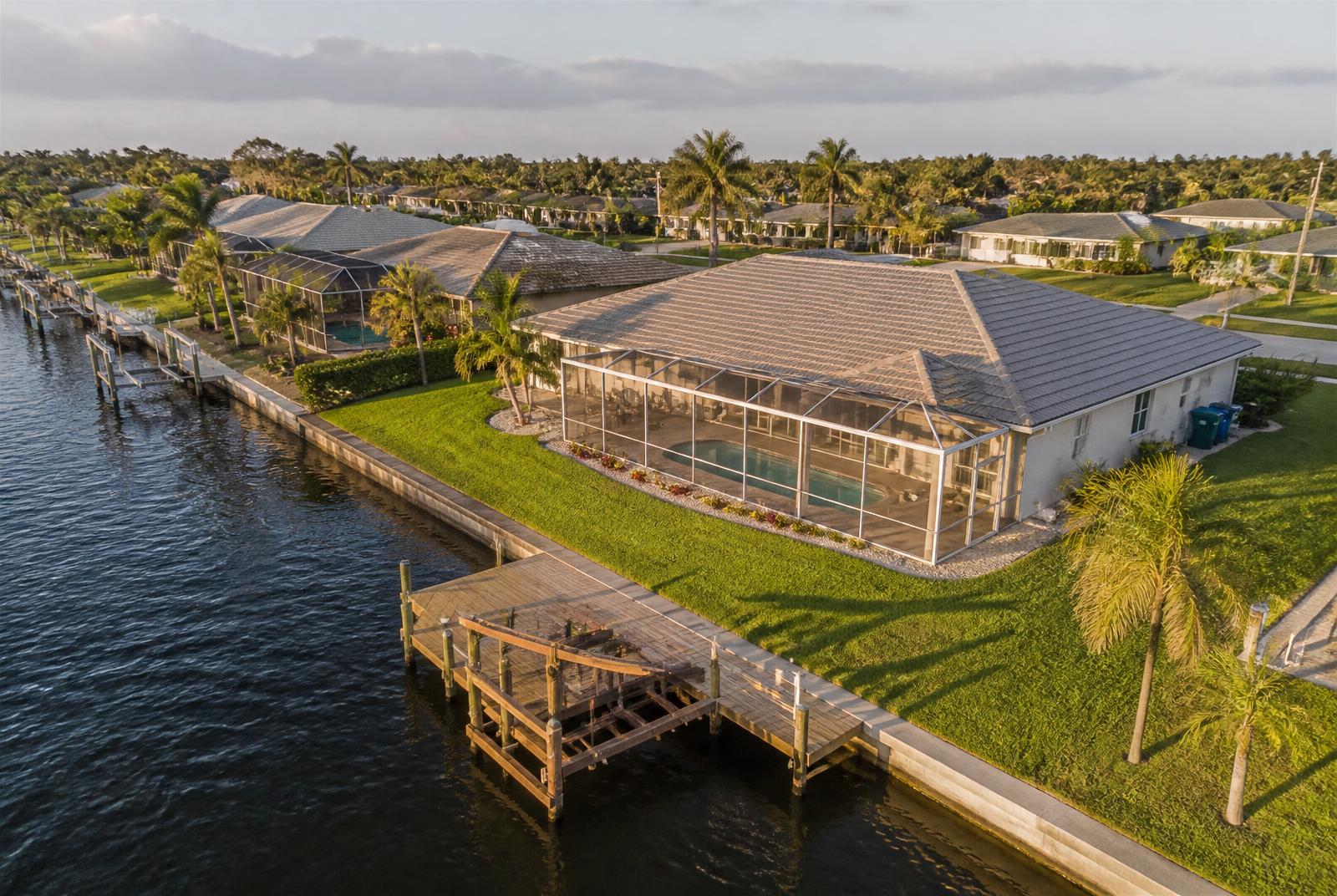 Aerial view of the Gulf-access canal home with dock